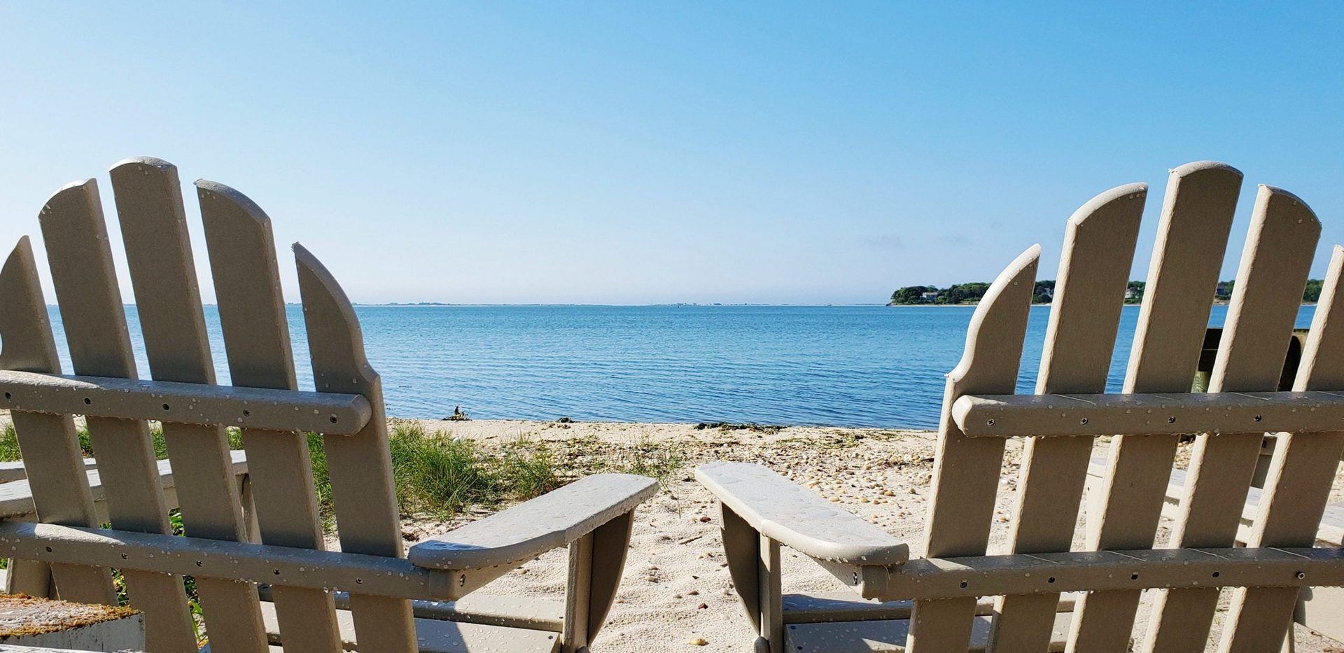 Adirondack chairs facing Shinnecock Bay near the pool deck at Ocean View Terrace Inn