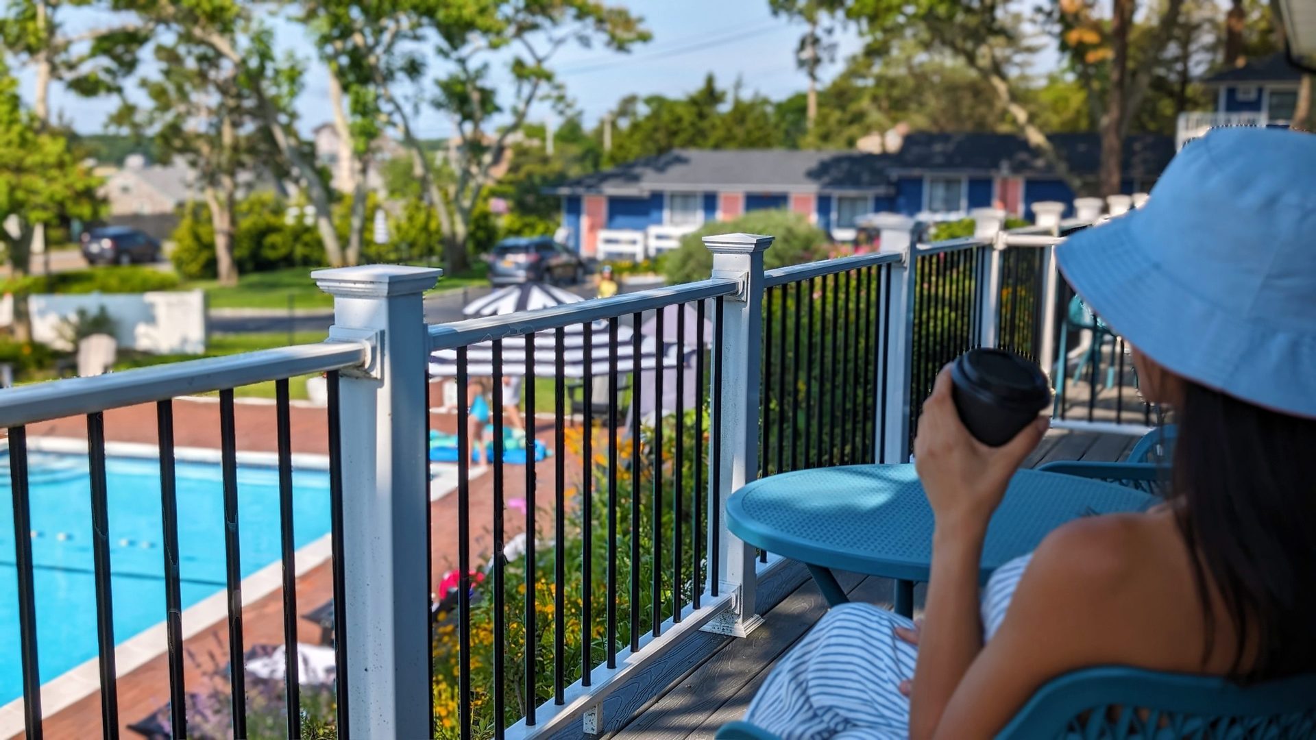 Seasonal outdoor pool with deck and umbrella views at Ocean View Terrace Inn, Hampton Bays, NY